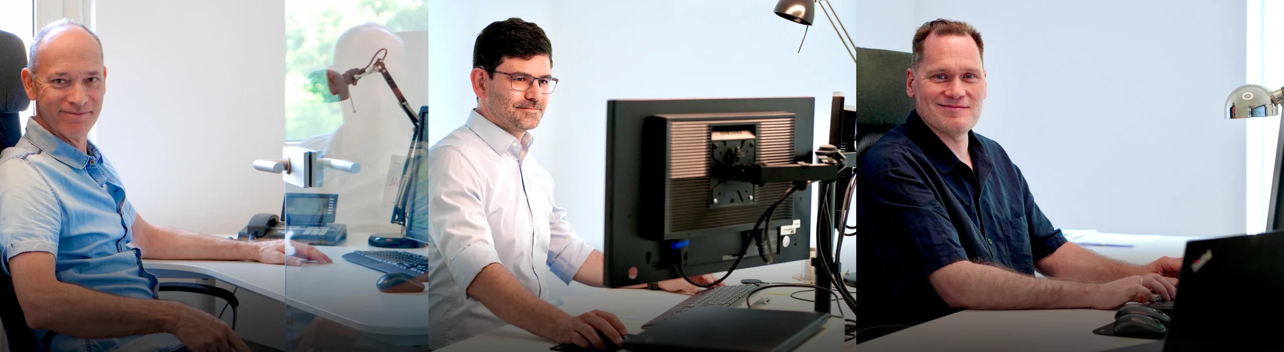 Drei Männer arbeiten in einem modernen Büro an ihren Schreibtischen.